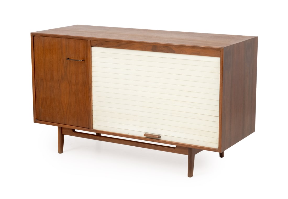 Jens Risom Walnut Credenza: Jens Risom Walnut Credenza, with single cabinet with three shelves and white vinyl tambour door opening to two shelves, Jens Risom Design Inc. label to reverse. 32" H x 54" W x 21" D. Provenance: From