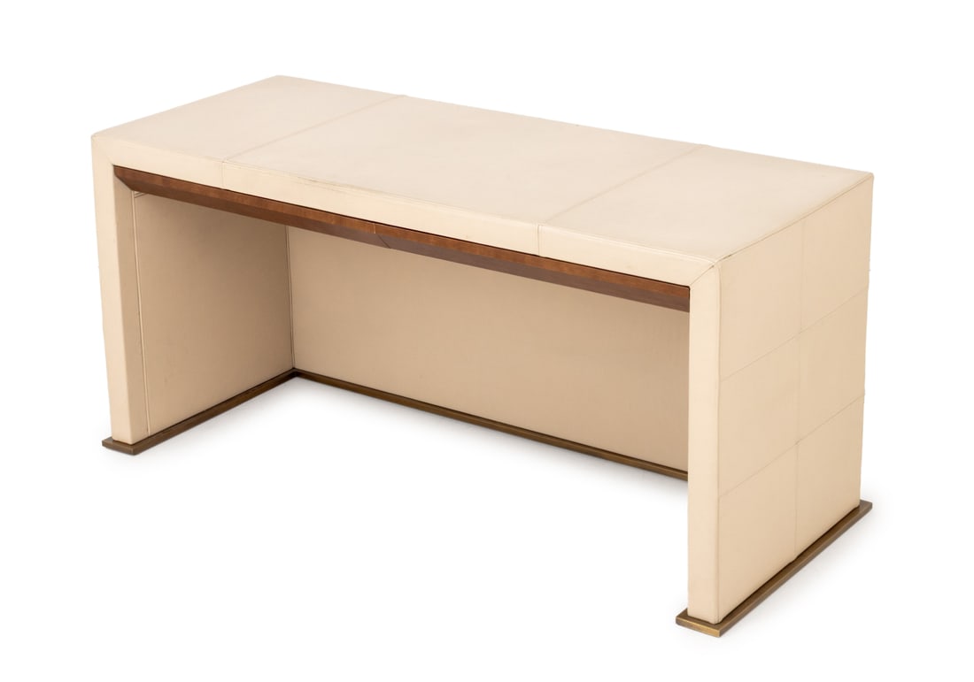 Promemoria Cream Leather Covered Writing Desk: Promemoria Cream Leather Covered Writing Desk, with two wood drawers mounted on brass base, "Promemoria" label to underside. 30" H x 63" W x 26" D. Provenance: From a 480 Park Avenue Collection.