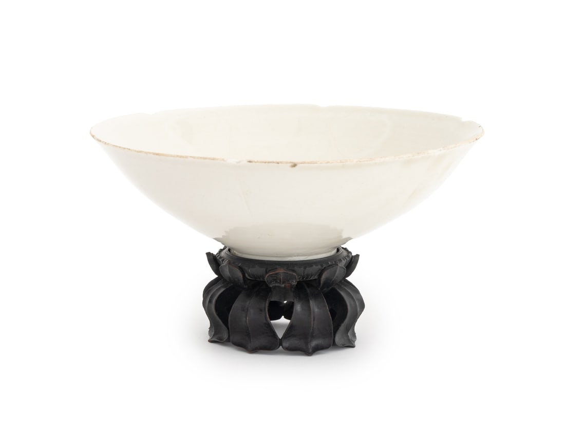Chinese Lotus Form Ding Ware Style Bowl: Chinese Lotus Form Ding Ware Style Bowl, white glazed porcelain, with a pierced carved wood stand. Overall: 4.5" H x 7.75" Diameter. Provenance: From a New York City Estate. Keywords: Chinese