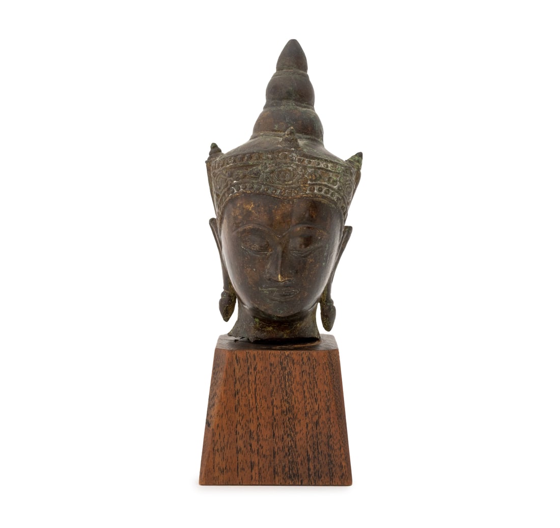 Thai Patinated Bronze Buddha Head, ca. 1700: Thai Patinated Bronze Buddha Head, circa 1700, mounted on a wood base. Overall: 7" H x 2.25" W x 2.25" D. Provenance: From a New York City Estate. Keywords: Ayutthaya Kingdom, Ayodhya, Siddhartha