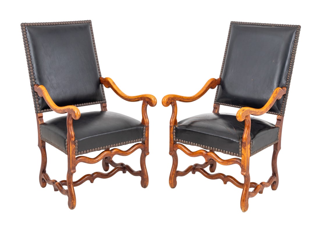 Louis XIV Style Walnut Fauteuils, Pair: Pair of Louis XIV Style Walnut Fauteuils, each with riveted black leather upholstery on four carved wood legs conjoined by H-form stretcher. 44" H x 24" W x 25" D; seat: 18.25" H. Provenance: From an