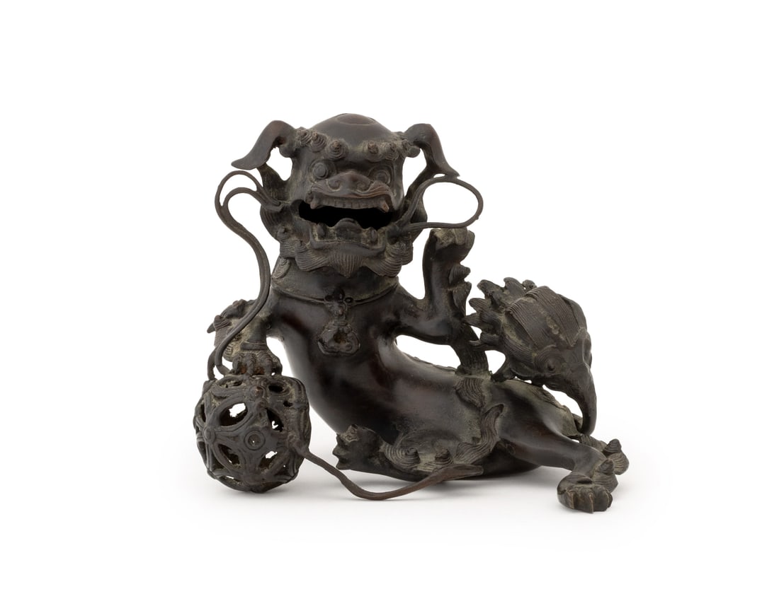 Japanese Buddhistic Lion Patinated Bronze Censer: Japanese Buddhistic Lion Patinated Bronze Censer, two character mark to underside, the seated shishi dog with reticulated orb under paw and cover to back. 6.5" H x 8.5" W x 6" D. Provenance: From a