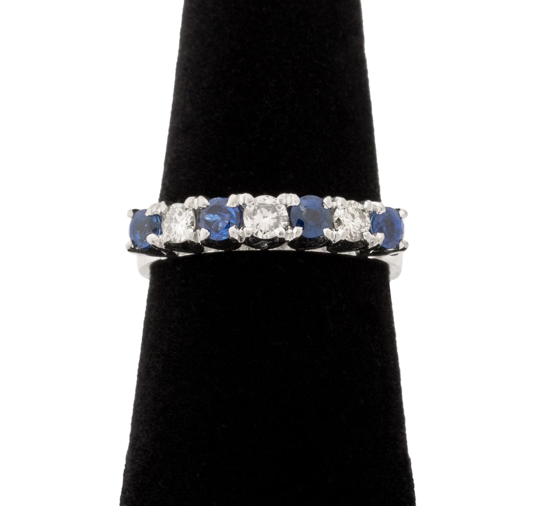 14K White Gold Sapphire and Diamond Band: 14K White Gold Sapphire and Diamond Band, featuring four prong set round brilliant cut blue sapphires weighing a total of approx. 0.55 carat, further adorned with three prong set round brilliant cut d