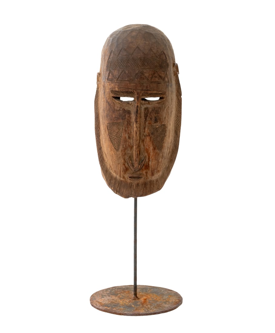 African Dogon Hand-Carved Wood Mask: African Dogon Hand-Carved Wood Mask, mounted on a cast iron stand. Overall: 21" H x 7" Diameter. Provenance: From an Upper West Side, New York City Estate. Keywords: West African Art, Mali, Carving, S