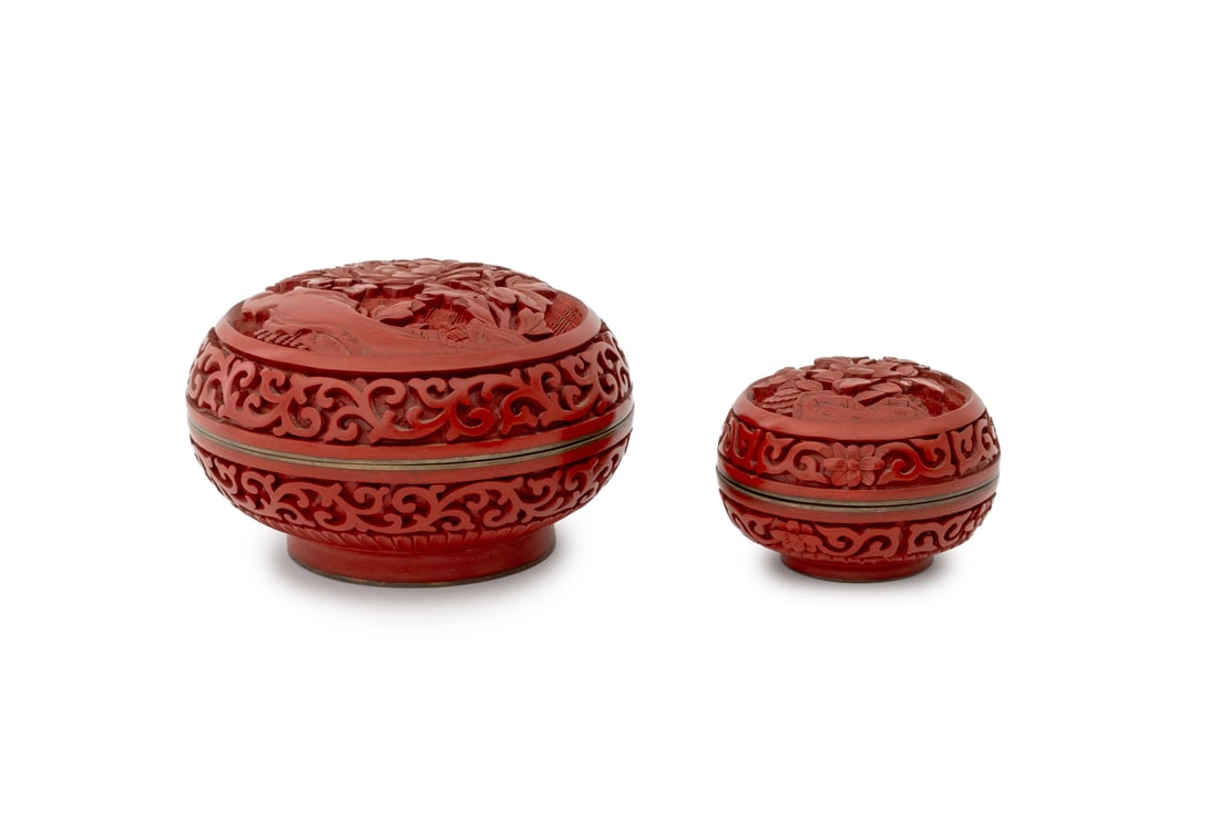 Chinese Red Cinnabar Covered Boxes, 2: Two Chinese Red Cinnabar Lacquer Covered Circular Boxes, each carved with floral motif and raised on a circular foot. Larger: 2.75" H x 4.25" Diameter. Provenance: From a New York City Estate. Keyword