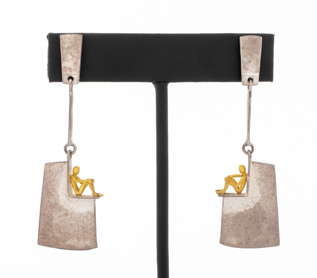Modern 18K Gold and Sterling Silver Earrings: Pair of Modern Sterling Silver and 18K Yellow Gold Earrings, with seated figure, marked "925 AG, 750 AU" with illegible circular maker's mark stamp. Silver and gold tested. 2.25" L x 0.75" W; weight 0