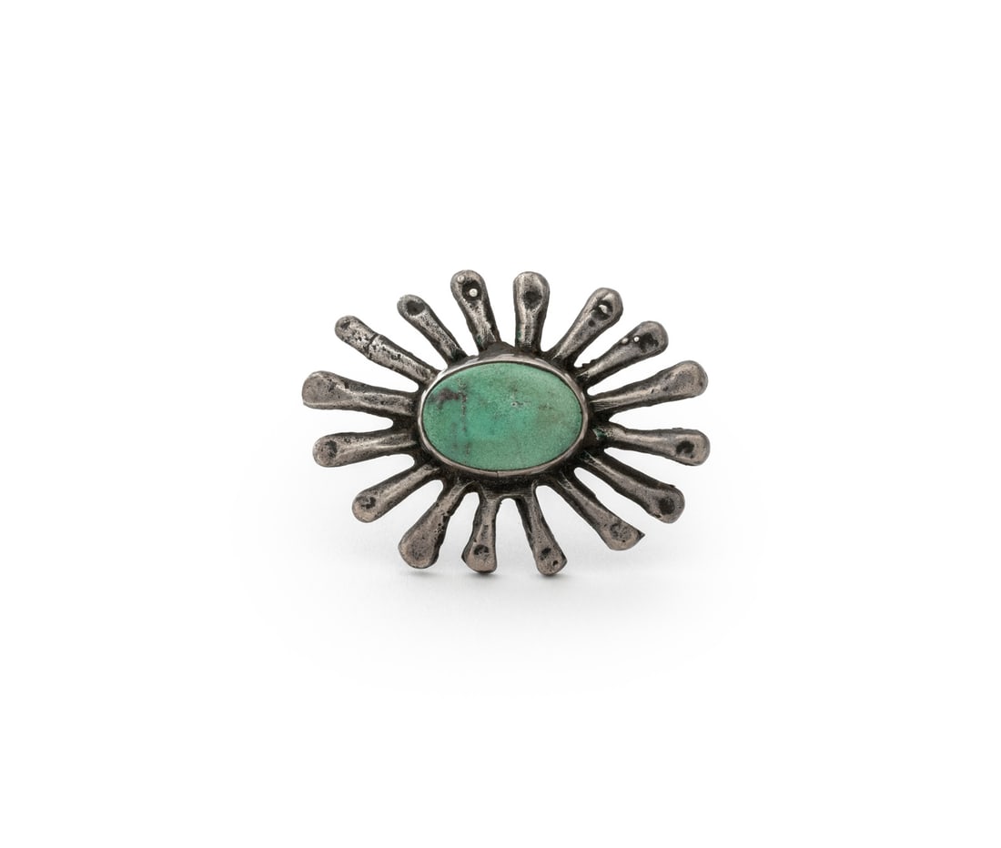 Navajo Dine Turquoise and Silver Sunburst Brooch: Navajo Dine Turquoise and Silver Sunburst Brooch, with sixteen stylized rays centering a blue turquoise cabochon. Silver tested. Weight: 0.34 ozt. inclusive; 1.5" L x 1.25" W. Provenance: From the Est
