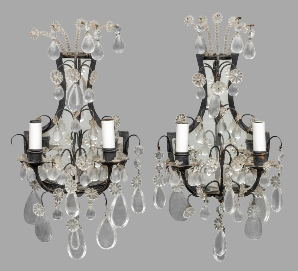 Louis XVI Style Patinated Metal Crystal Sconces, 2: Pair of Louis XVI Style Cut Crystal Patinated Metal Two-Light Wall Sconces, with mirrored urn form back plate and cut crystal drop prisms and flowers. 15.5" H x 8.25" W x 4.75" D. Provenance: From a N