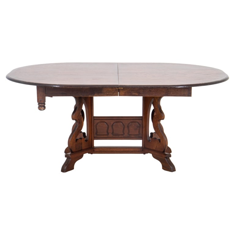 Spanish Renaissance Revival Oak Dining Table: Spanish Renaissance Revival Oak Oval Extending Dining Table, raised on carved pedestal base, with two leaves. Without leaves: 28.5" H x 66" W x 48" D; each leaf: approx. 11.5" W. Provenance: From a Ne