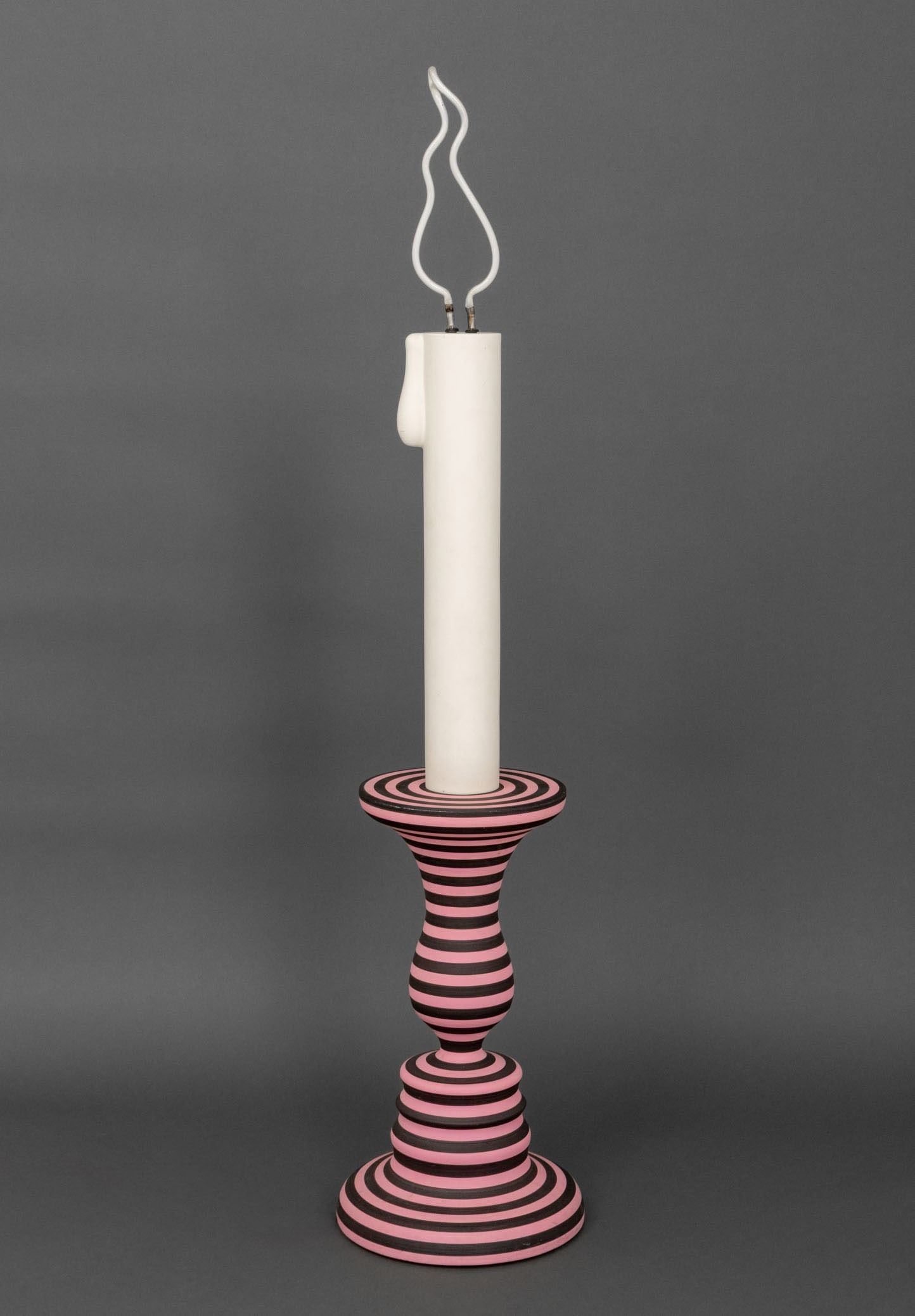Greg Ito Candlestick Form Floor Lamp, ca. 2019: Greg Ito (Japanese/American, b. 1987) Candlestick Form Floor Lamp, circa 2019, pink and black striped painted wood base with flame form light bulb, unsigned. 63" H x 13" Diameter. Provenance: From a L