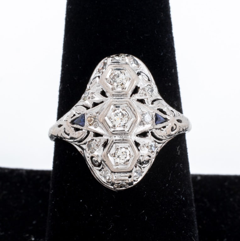 Art Deco Platinum Diamond Sapphire Ring: Art Deco Platinum Diamond and Sapphire Ring, adorned with 15 round diamonds weighing total of approx. 0.36 carat, further decorated with two French cut synthetic blue sapphires weighing a total of
