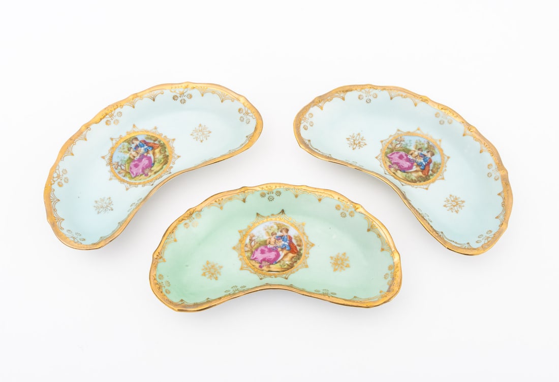 Royal Vienna Crescent Shapes Dishes, 3: Set of Three Royal Vienna Crescent Shapes Dishes, each with painted courting scene roundel to the center and gilt trim, cobalt beehive mark to underside. 1.25" H x 7.25" W x 4.5" D. Provenance: From