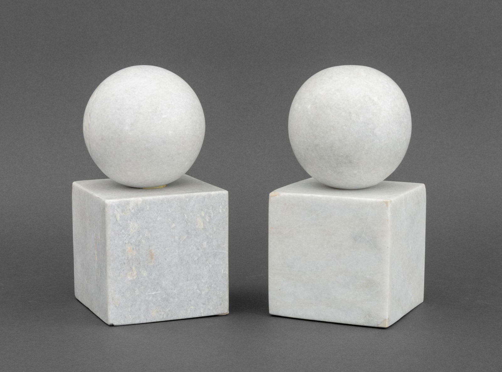 Aero White Quartzite Geometric Bookends, Pair: Pair of Aero White Quartzite Geometric Bookends, each with a sphere atop a cube and Aero NYC label to underside. 8.25" H x 4.25" W x 4.25" D. Provenance: From a One Central Park West Estate.