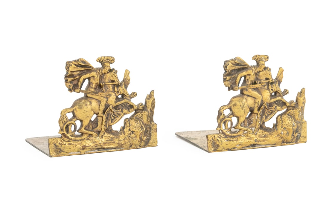 St. George Slaying Dragon Brass Bookends, Pair: Pair of Saint George Slaying the Dragon Motif Brass Bookends. 4.25" H x 5.25" W x 4" D. Provenance: From a Connecticut Estate. Keywords: Bookshelf accessories, Bookcase accessory, Sculpture,