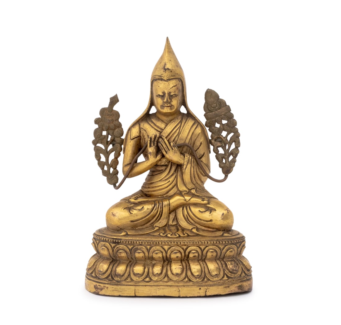 Tibetan Tsongkhapa Gilt Bronze Sculpture: Tibetan Je Tsongkhapa Gilt Bronze Sculpture, 19th century or earlier, the monk flanked by removable lotus petals, wearing a pandita hat and monastic robes, and seated atop a double lotus pedestal. 5.2
