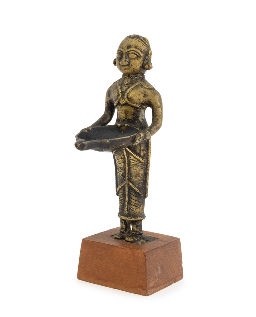 Indian Brass Deeplakshmi Figural Oil Lamp: Indian Brass Deeplakshmi Figural Oil Lamp, mounted on wood base. Overall: 9.25" H x 4.5" W x 3" D. Provenance: From a 860 5th Avenue Collection. Keywords: South Asian Art, Statue, Goddess, Hindu, Hind