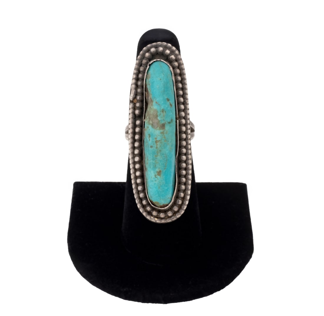 Sterling Silver Elongated Turquoise Ring: Sterling Silver Elongated Turquoise Ring, featuring one bezel set oval turquoise cabochon weighing approx. 15.50 carats. Silver tested. Measuring approx. US size 6 1/4, 0.49 ozt. Provenance: From a Ne