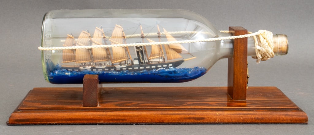 S.S. Great Britain Ship Model in a Bottle, 1994: S.S. Great Britain Ship Model in a Glass Bottle, executed by Captain George Villiers-Furze, 1994, signed with label to underside and mounted on oak wood support. 6" H x 15" L x 6" D. Provenance: From 