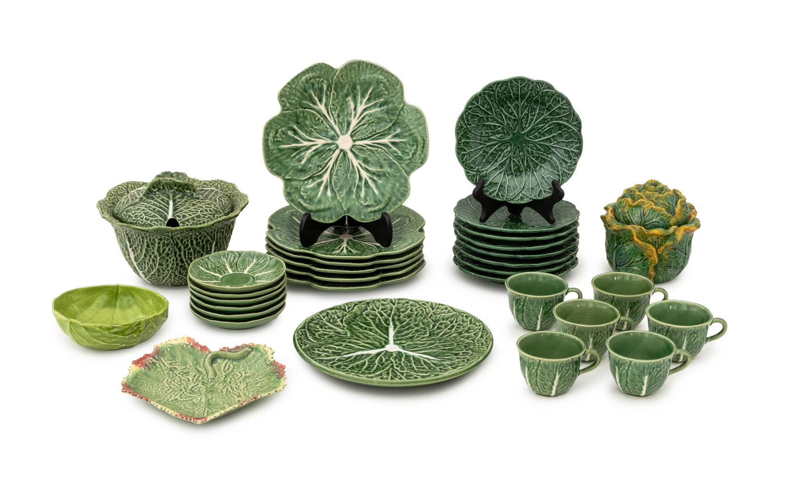Green Cabbage Leaf Ceramic Tableware, 31 Pcs.: Collection of 31 Green Cabbage Leaf Ceramic Tableware Pieces, comprising: (6) six teacups, (6) six saucers, marked "Gracious Home / Made in Portugal" to underside, Barbara Eigen (American, XX-XXI), ca