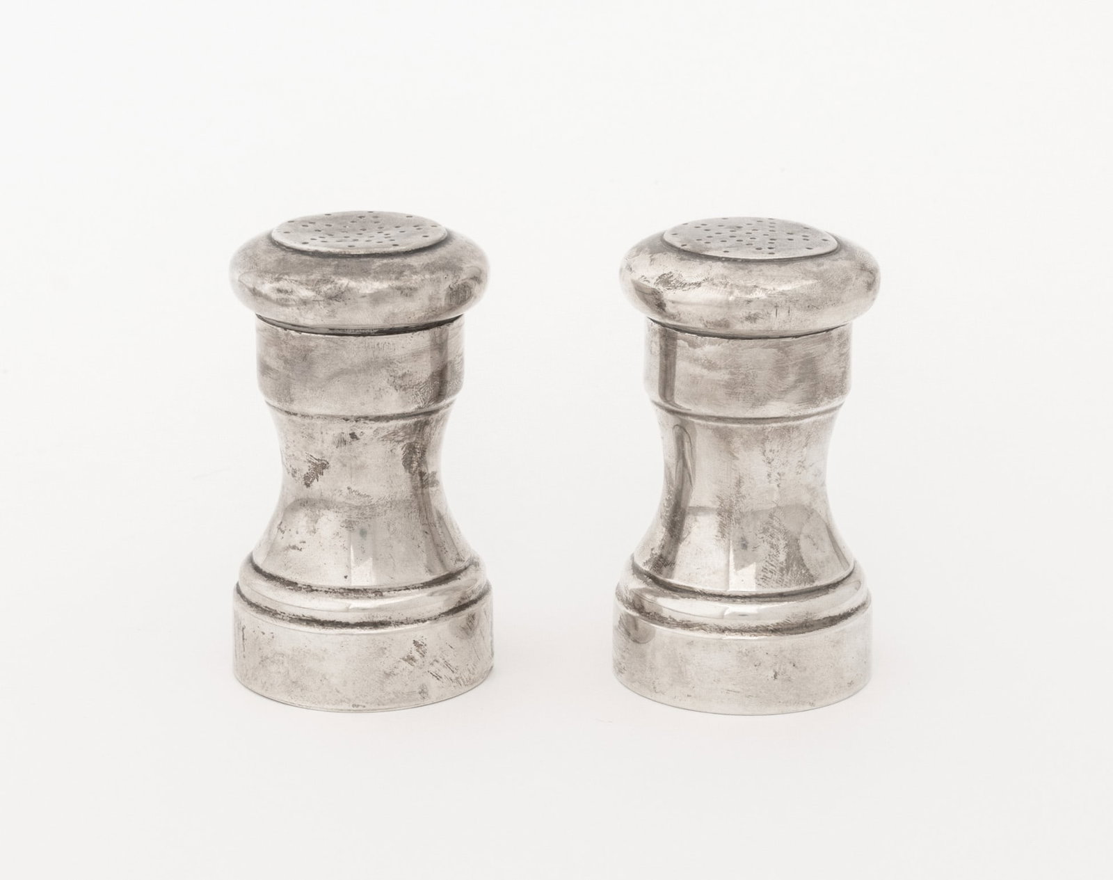 Tiffany & Co. Makers Sterling Silver Shaker Set, 2: Tiffany and Company Makers Sterling Silver Salt and Pepper Shakers, each marked "Tiffany & Co. / makers / Sterling / 23977" to underside. Weight: 7.28 ozt.; 3.5" H x 2" Diameter. Provenance: From a