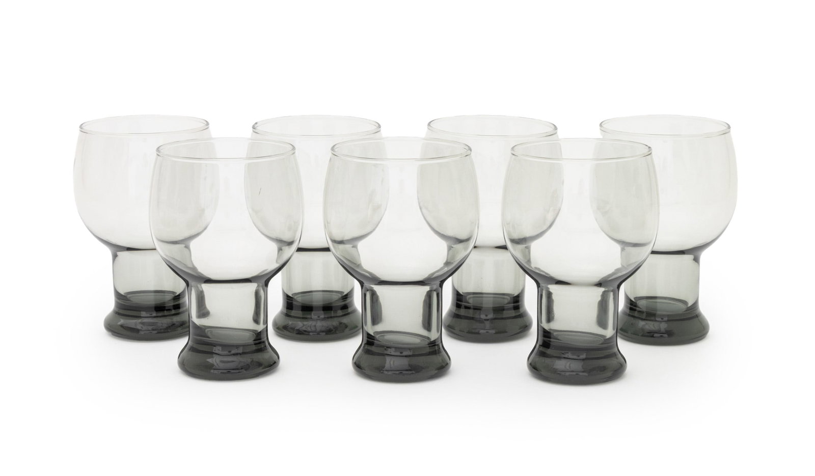 Modern Smoky Glass Drinking Goblets, 7: Set of Seven Modern Smoked Glass Drinking Goblets, unmarked. 5.5" H x 3.25" Diameter. Provenance: From a Connecticut Estate. Keywords: Glassware, Drinkware, Cups, Cocktail glasses, Vintage, Smoky glas