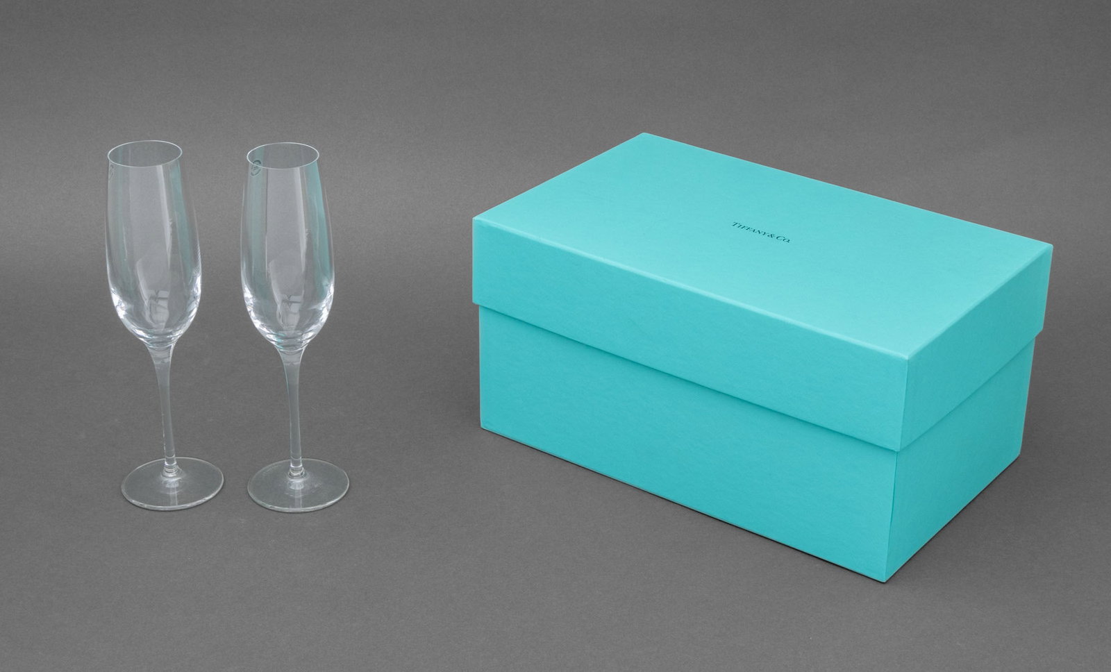 Tiffany & Co. Crystal Champagne Glasses, Pair: Pair of Tiffany and Company Crystal Champagne Glasses, marked "Tiffany & Co." to the underside, with blue Tiffany box. 9.75" H x 2.75" Diameter. Provenance: From a Warren Collection. Keywords:
