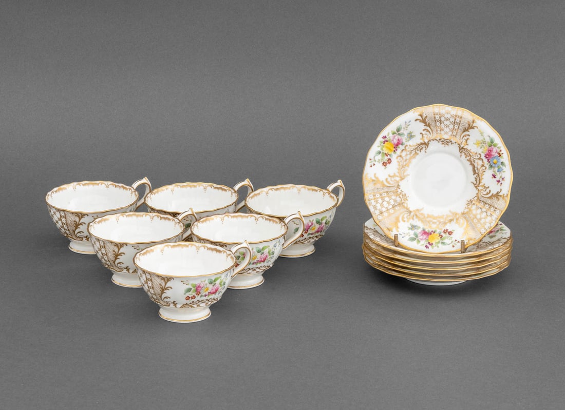 Wedgwood Porcelain Teacups and Saucers, 11: Set of Wedgwood Porcelain Teacups and Saucers, with hand-painted floral and gilt scrollwork motif, comprising: (5) five teacups and (6) six saucers, marked to underside. 11 pieces total. Overall:
