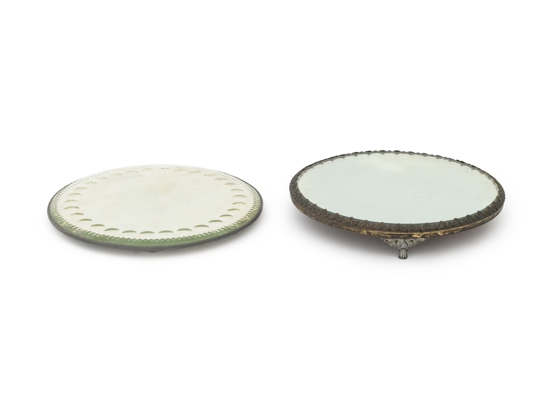 Art Deco Mirrored Trays, 2: Two Art Deco Mirrored Trays, one with cut glass border and one with beveled glass top above tripod base. Taller: 10" Diameter x 1.75" H. Provenance: From a Connecticut Estate. Keywords: Vanity accesso