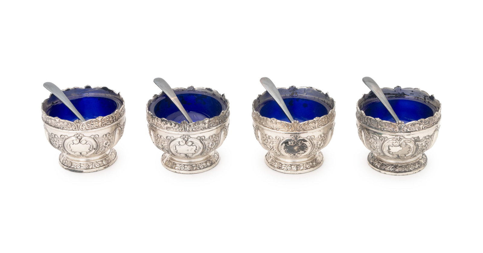 Cobalt Blue Glass and Silver Plate Salt Cellars, 4: Set of Four Cobalt Blue Glass and Silver Plate Open Salt Cellars, repousse floral motif, each marked "Japan" underside, with spoons marked "Nickel Silver" underside, with grey fitted case. Cellar: 1.7