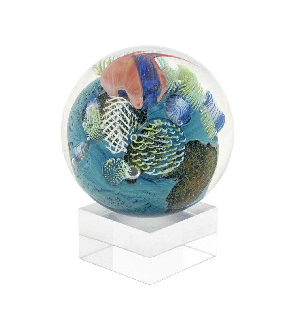 John Simpson "Planet" Art Glass Paperweight, 2018: John Simpson (American, b. 1949) "Planet" Art Glass Paperweight, 2018, signed and dated "JS 18" to underside, together with clear acrylic stand. Sculpture: 2.25" H x 2.25" Diameter. Provenance: The Es