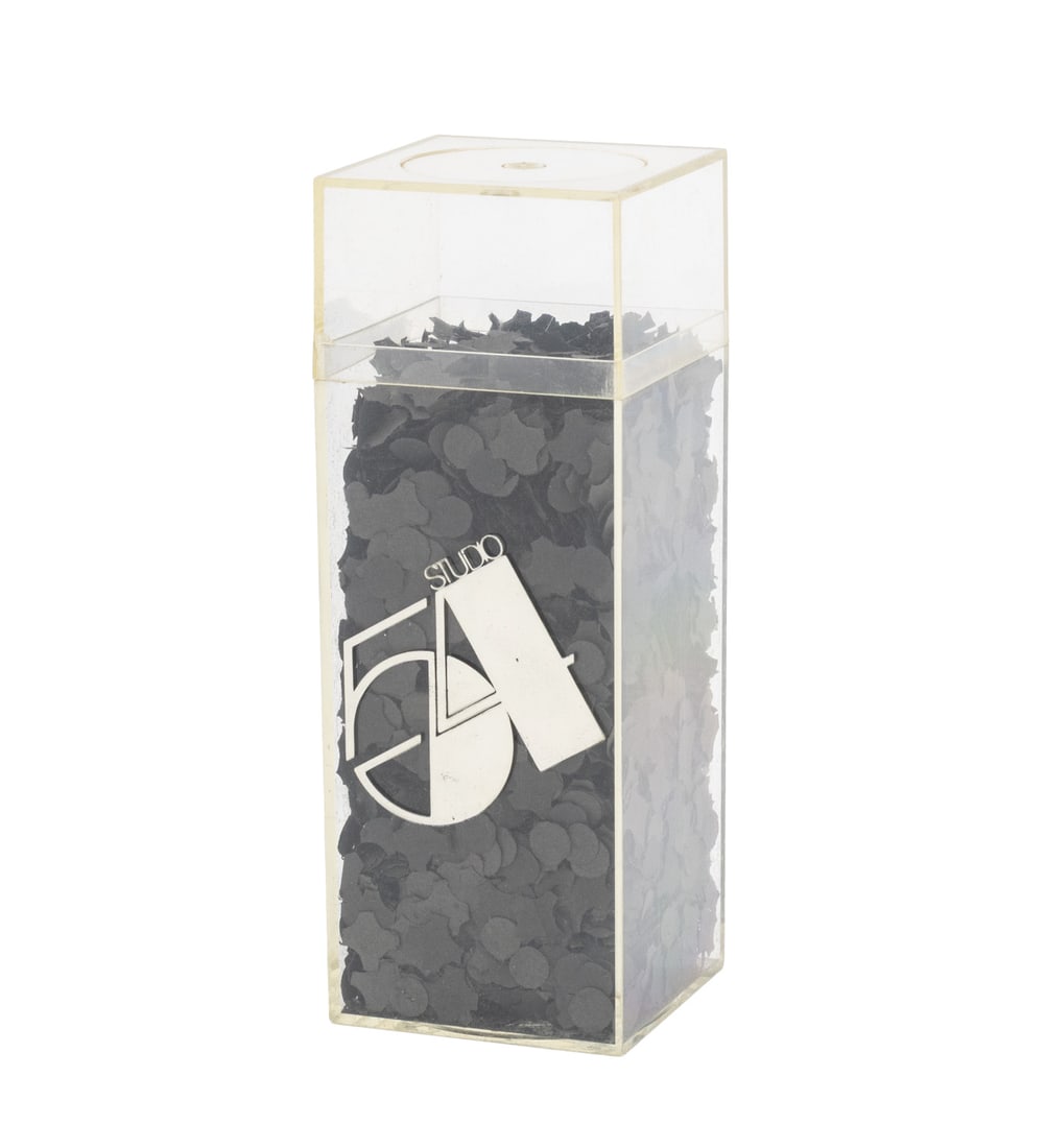 Studio 54 Gala Reopening Invitation, 1981: Studio 54 Gala Reopening Invitation, 1981, black confetti in cleaar acrylic box, marked "AMAC Plastic Products Corp. Sausalito. Calif." to underside. 6.25" H x 2.25" W x 2.25" D. Provenance: From a Ce