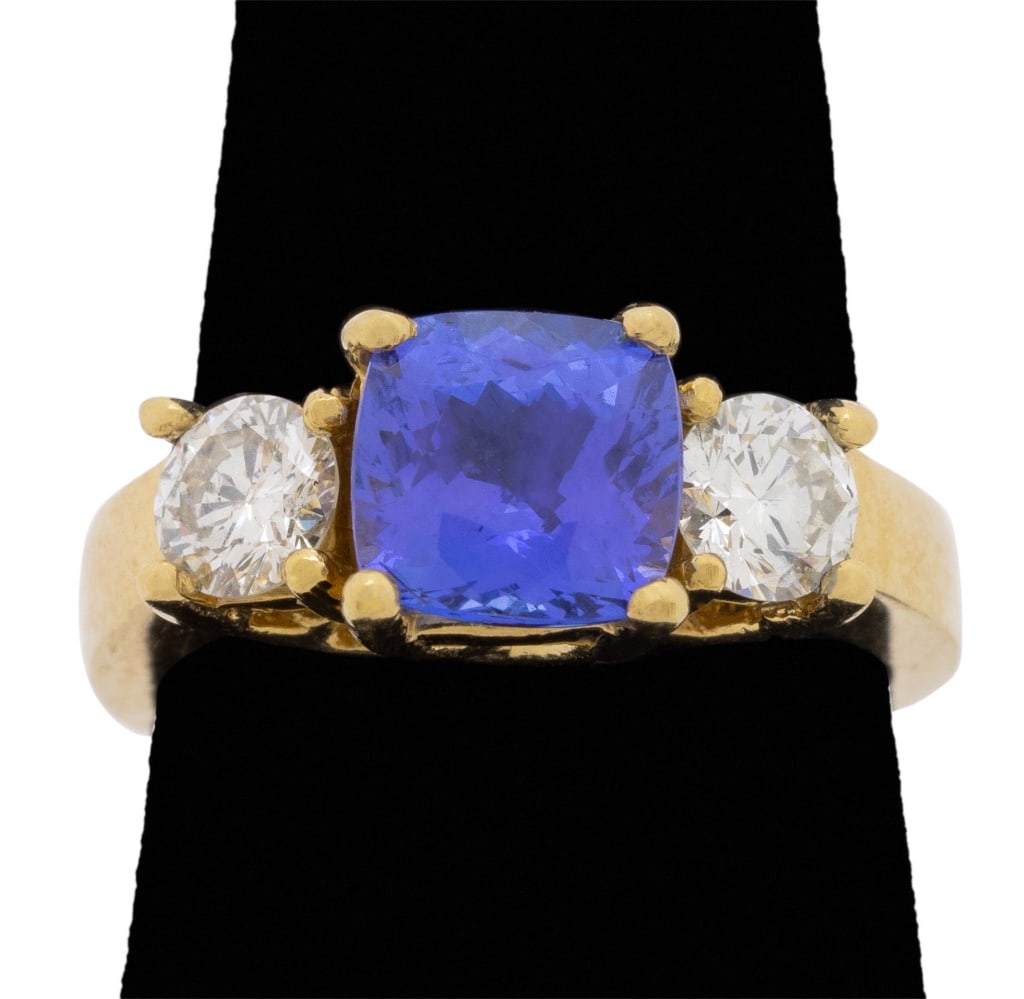 Tanzanite and Diamond 18K Yellow Gold Ring: Tanzanite and Diamond 18K Yellow Gold Ring, featuring one prong set cushion brilliant tanzanite weighing approx. 1.75 carats, further adorned with two prong set round brilliant cut diamonds weighing a