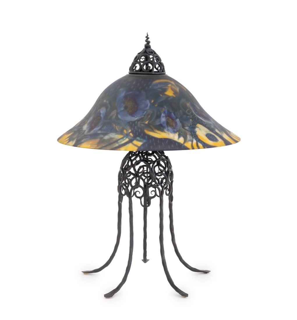 Ulla Darni Reverse Painted Glass Table Lamp: Ulla Darni (Danish/American, 1937-2022) Reverse Painted Glass and Wrought Iron Table Lamp, blooming floral design, signed "Ulla" to shade, swirling designs to ironwork body. 28" H x 19" Diameter. Prov