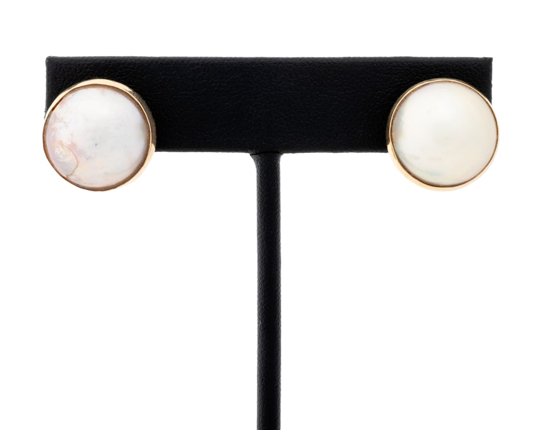 Mabe Pearl Yellow Gold Earrings: Pair of Mabe Pearl 14K Yellow Gold Earrings, featuring two bezel set round mabe pearls approx. 14.5 - 15.0 mm., worn through pierced earlobes with fixed posts and large friction backs, marked: "14K".