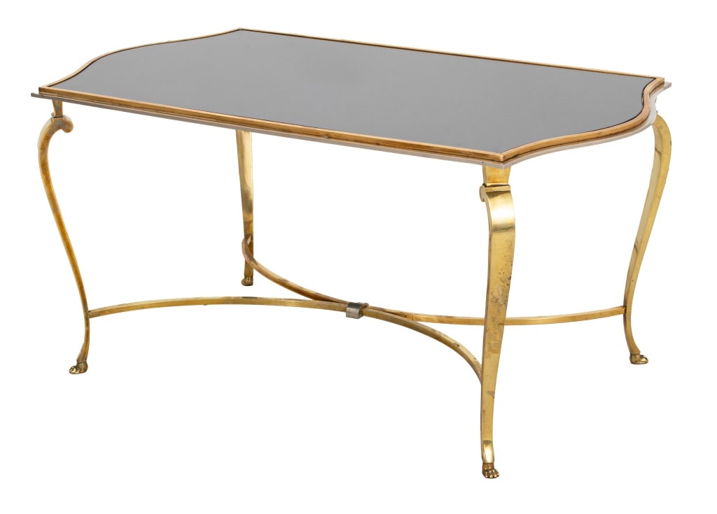Hollywood Regency Glass Top Coffee Table: Hollywood Regency Brass and Smoked Glass Top Coffee Table, with chromed edge, X-form stretcher, and paw feet. 18" H x 36" W x 20" D. Provenance: From a New York City Collection. Keywords: Vintage Furn