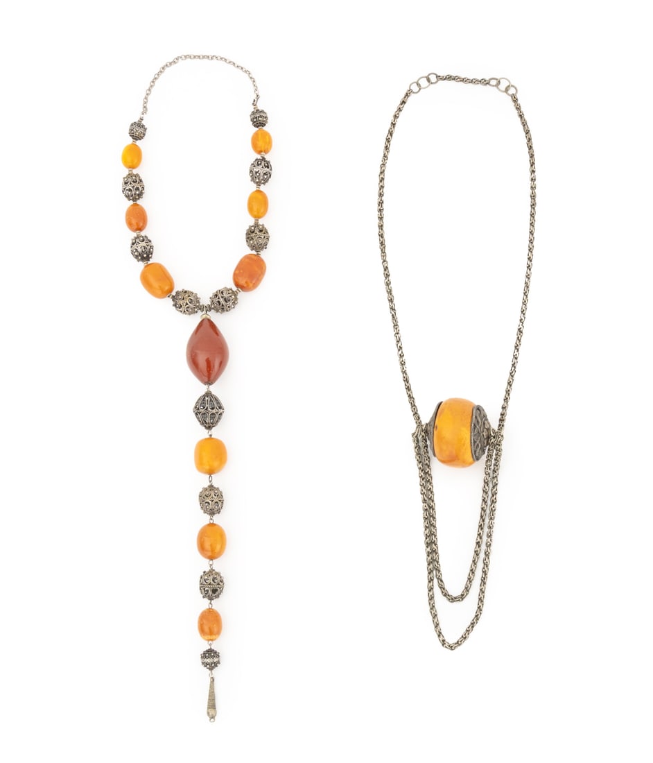 Tribal Silver and Copal Amber Bead Necklaces, 2: Two Tribal Silver and Copal Amber Bead Necklaces, one with openwork filigree beads, and one with a Tibetan silver serpent motif pendant. Silver tested and not weighable. Filigree: 20" L x 13" W. Prove