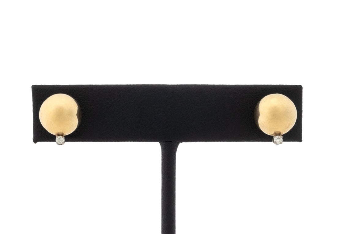 Modern Yellow Gold Ball and Diamond Earrings: Pair of Modern 14K Yellow Gold Ball and Diamond Earrings, featuring two 14K gold balls adorned with two prong set round brilliant cut diamonds weighing a total of approx. 0.05 carat, worn through
