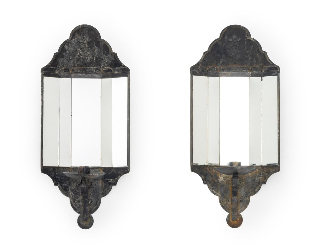 American Primitive Mirrored Tin Candle Sconces, 2: Pair of American Primitive Mirrored Tin Candle Wall Sconces, 19th century, with five-panel mirrors, single candle holder and molded flower to the top. 16.75" H x 7.5" W x 4.25" D. Provenance: From a 2