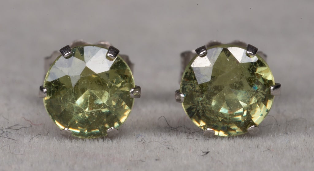 Green Gemstone and White Gold Stud Earrings: Pair of Green Gemstone 14K White Gold Stud Earrings, 5mm round-cut faceted green stones, marked: "FI / 14K". 0.562" L x 0.187" W. Approx: 0.4 dwt. inclusive. Provenance: From a New York City Collectio