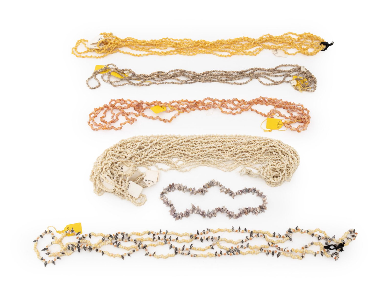 Collection of Miniature Seashell Beads: Collection of Miniature Sea Shell Beads, some pink, yellow, and white. Largest bead: 0.75" L x 0.25" W. Provenance: From the Estate of Jewelry Designer Irena Corwin. Keywords: Marine Specimens,