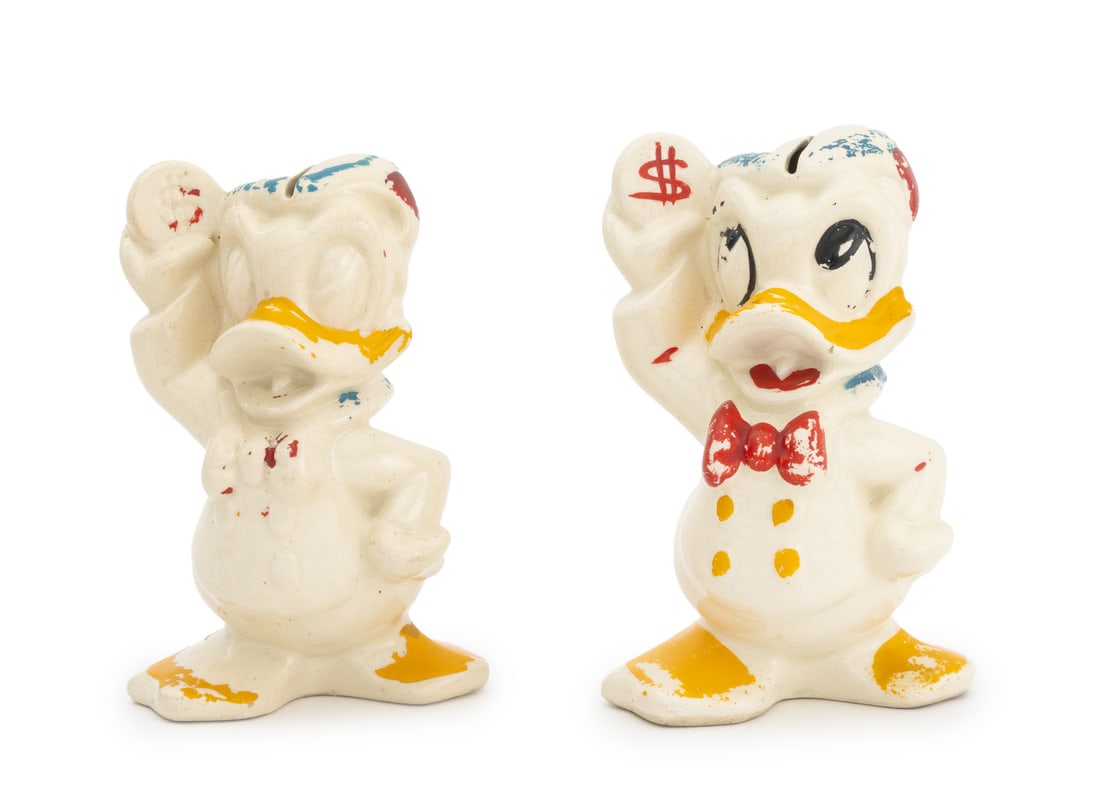 Leeds & Disney "Donald Duck" Coin Banks, Pair: Pair of Leeds Pottery and Walt Disney "Donald Duck" Ceramic Coin Banks, 1940s, each marked "Walt Disney U.S.A." to reverse. 6.5"{ H x 4.25" W x 3.75" D. Keywords: Piggy bank, Coin bank, Sculpture,