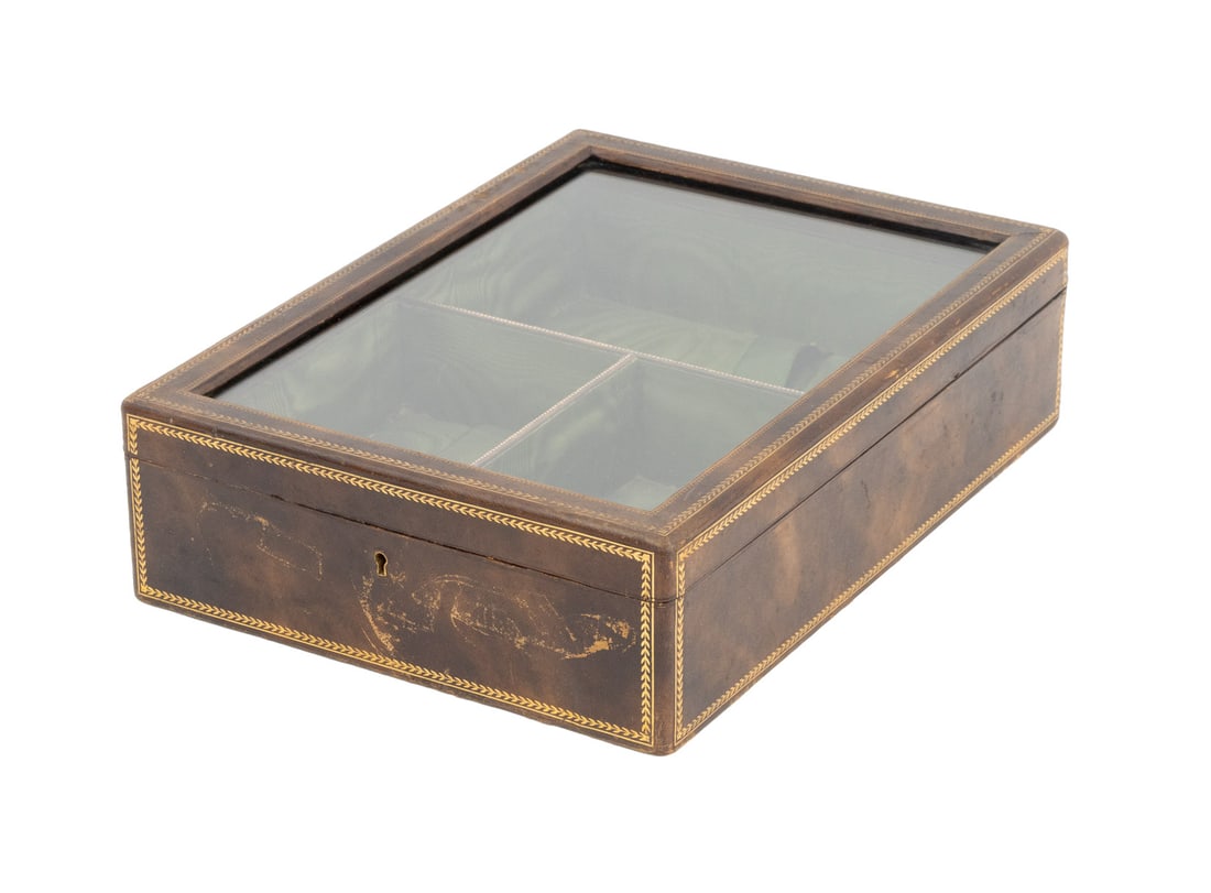 Art Deco Gilt-Tooled Leather Covered Display Box: Art Deco Gilt-Tooled Leather Covered Display Box, with glass lift top opening to green silk lined divided interior. 3.75" H x 10.25" W x 14 "D. Provenance: From a Westchester County Estate. Keywords: