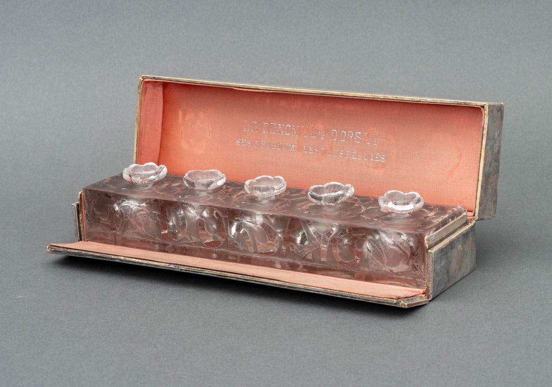 R. Lalique "La Renomee d'Orsay" Perfume Sampler: Rene Lalique "La Renomee d'Orsay" Clear and Frosted Glass Perfume Sampler, 1920s, with five chambers and individually marked and numbered floral stoppers, in original box. 2.5" H x 9" W x 2.5" D. Prov