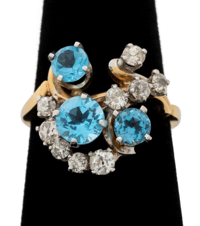 Vintage Blue Topaz and Diamond Two-Tone Gold Ring: Vintage 14K Yellow Gold and White Gold Blue Topaz and Diamond Ring, featuring three prong set blue topaz weighing approx. 1.40 carats, further adorned with nine prong set round faceted diamonds weighi