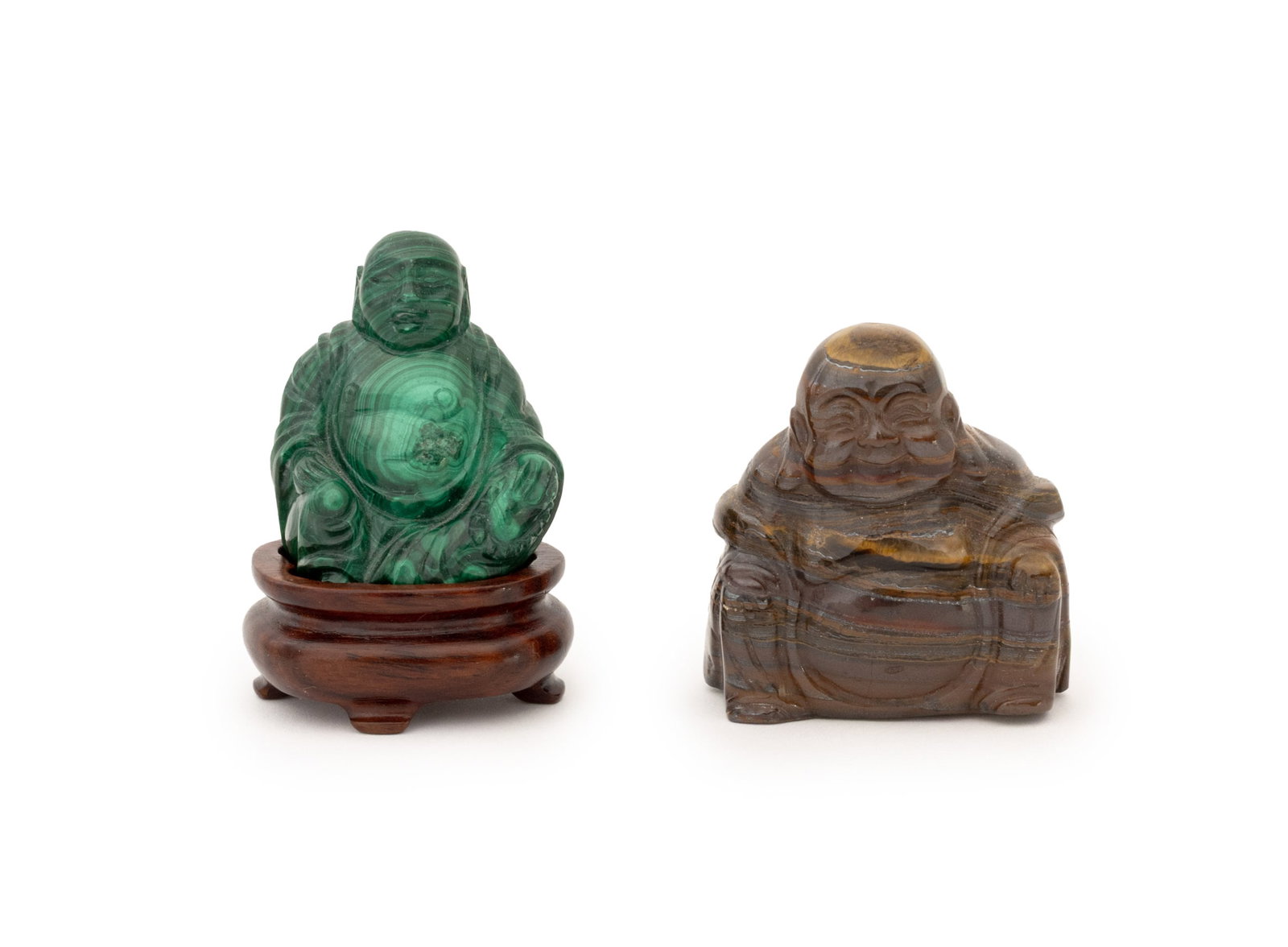 Chinese Seated Buddha Carved Stone Figurines, 2: Collection of Two Chinese Seated Buddha Carved Semi-Precious Stone Figurines, one of tiger's eye and the other carved malachite with wood pedestal stand. Tiger's eye: 2" H x 1.75" W x 1" D. Provenance