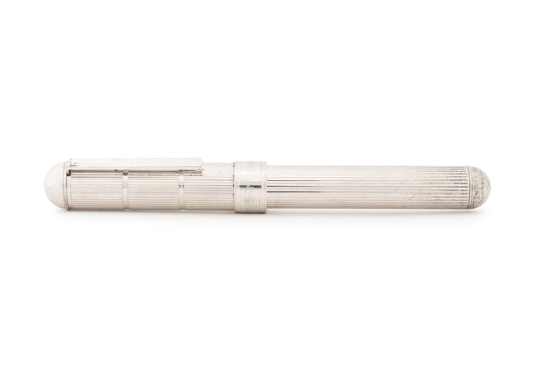 Yves Saint Laurent Fluted Fountain Pen: Yves Saint Laurent Fluted Fountain Pen, silver-tone case with vertical fluting, cap marked "Yves Saint Laurent" and reverse of clip marked "Made in France", nib marked "YSL". 5.5" L. Provenance: From 
