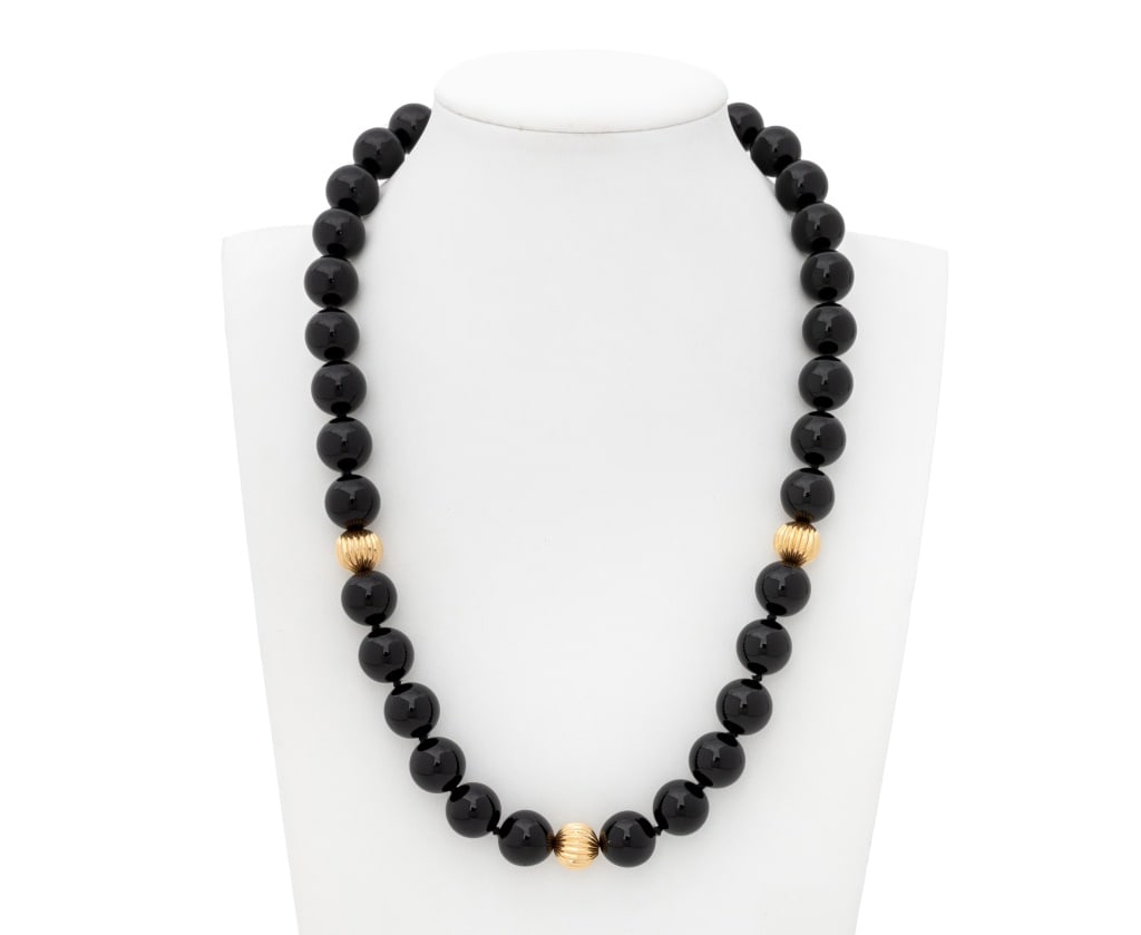 Black Onyx and Yellow Gold Beaded Necklace: 14K Yellow Gold and Black Onyx Beaded Necklace, featuring fully drilled round black onyx beads approx. 8.0-12.0 mm, further decorated with round fluted gold rondelles approx. 10.0 mm, joined with 14K 