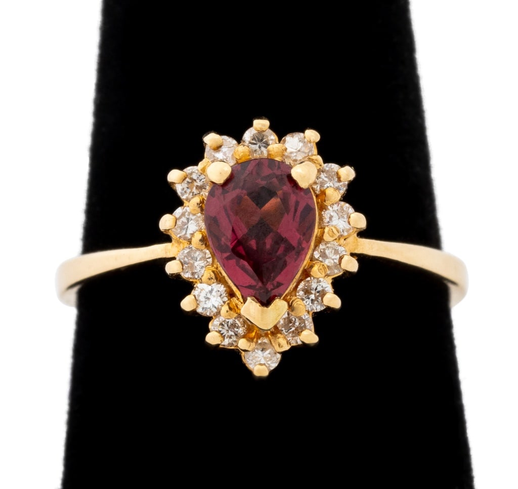 Rubellite and Diamond Yellow Gold Ring: 14K Yellow Gold Rubellite Diamond Ring, featuring one prong set pear brilliant cut rubellite weighing approx. 0.75 carat, further adorned with fourteen prong set round brilliant cut diamonds weighing 