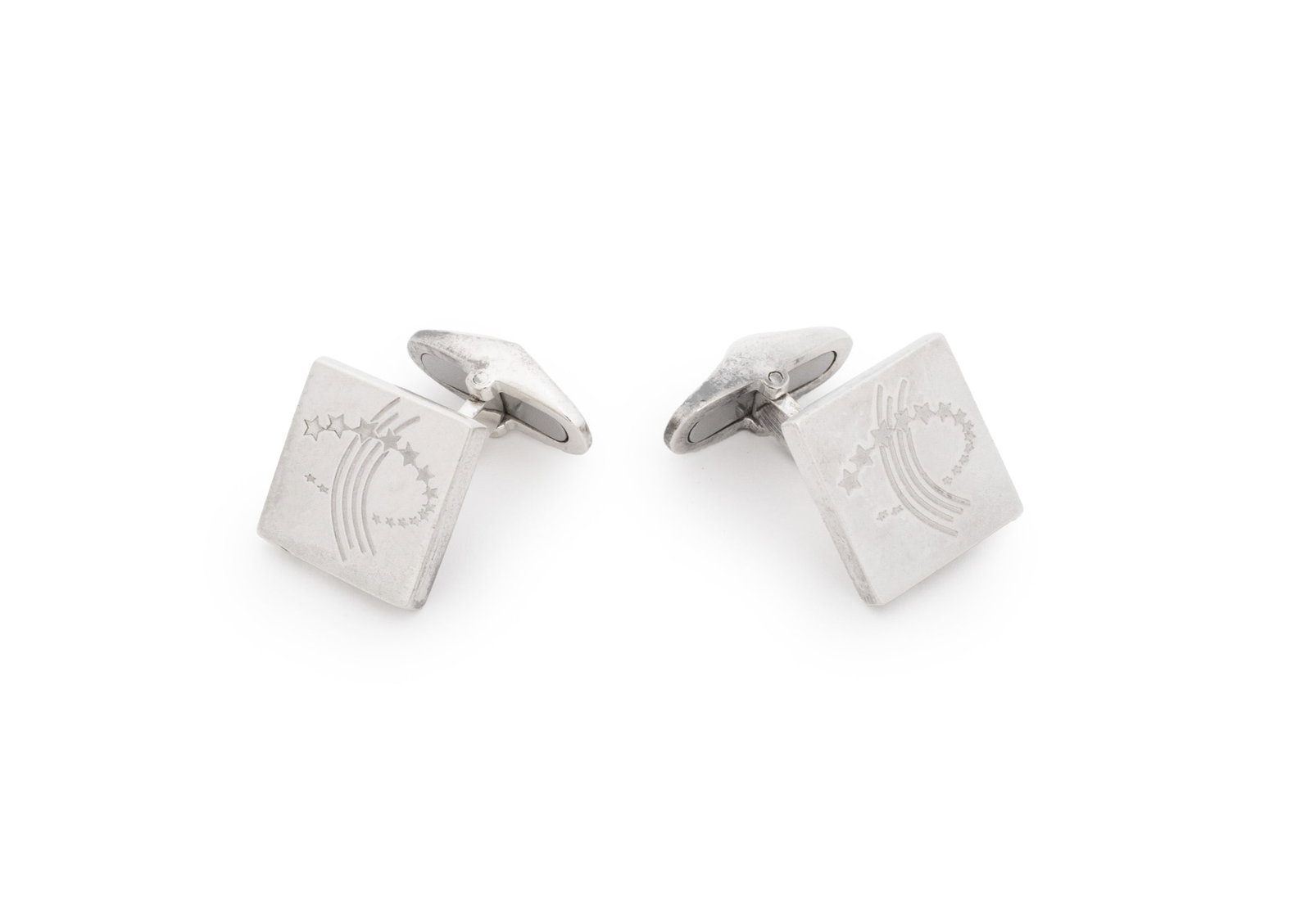 Garrard & Co. Silver Shooting Star Cufflinks: Pair of Garrard and Company Sterling Silver Shooting Star Cufflinks, featuring brightly polished surfaces with engraved stars and fluid lines, worn through French cuffs with whale backs decorated with