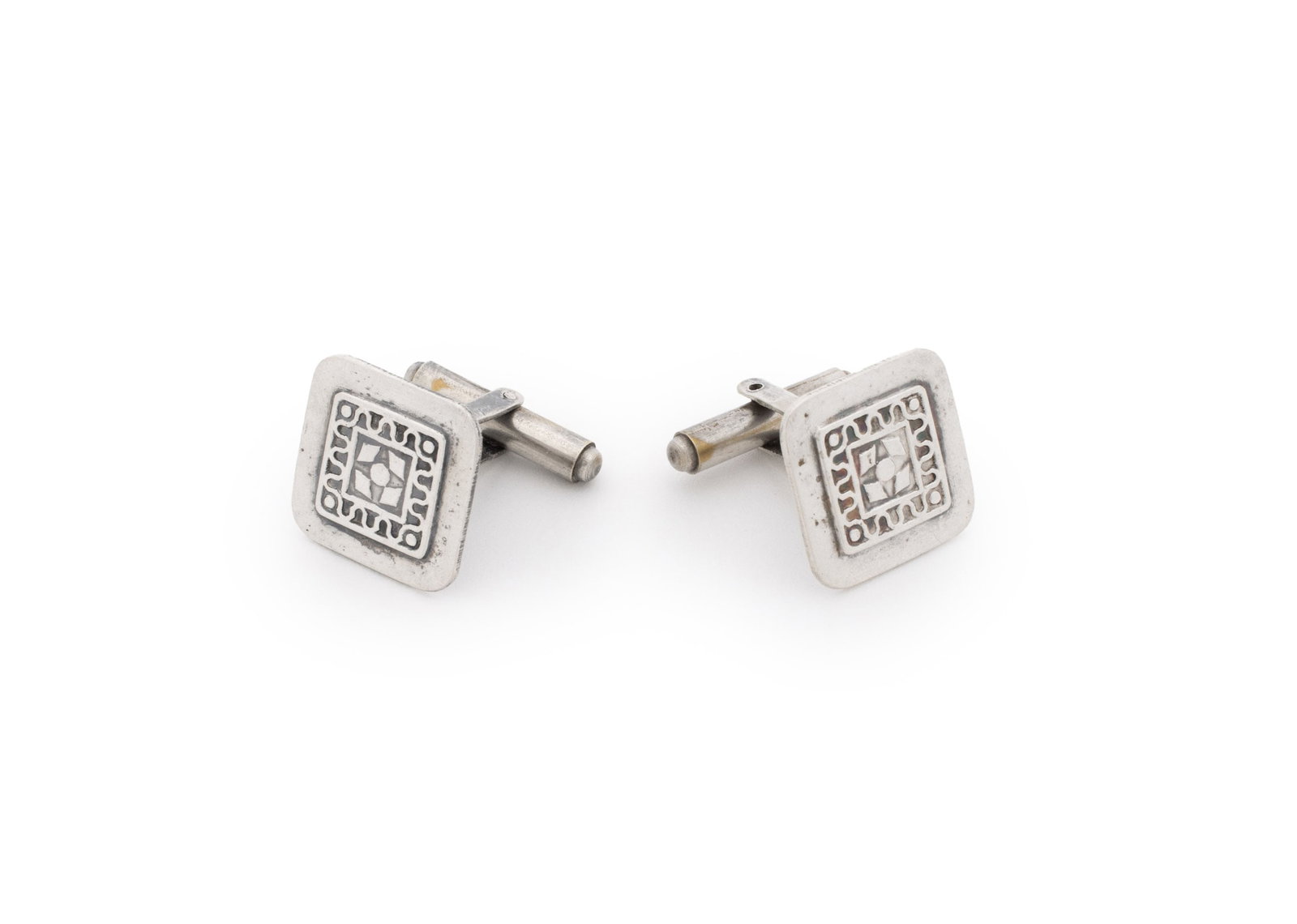 Sterling Silver Damascene Cufflinks: Pair of Sterling Silver Damascene Cufflinks, featuring inlaid square framed patterns of curved lines and geometric symbols, worn through French cuffs with bullet backs, marked: "{A1}". Silver Tested. 